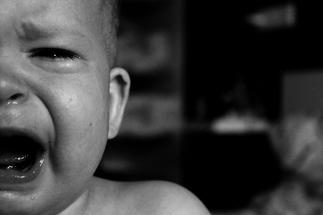 Close-up black and white photo of a crying baby