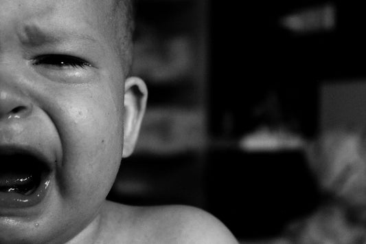 Close-up black and white photo of a crying baby